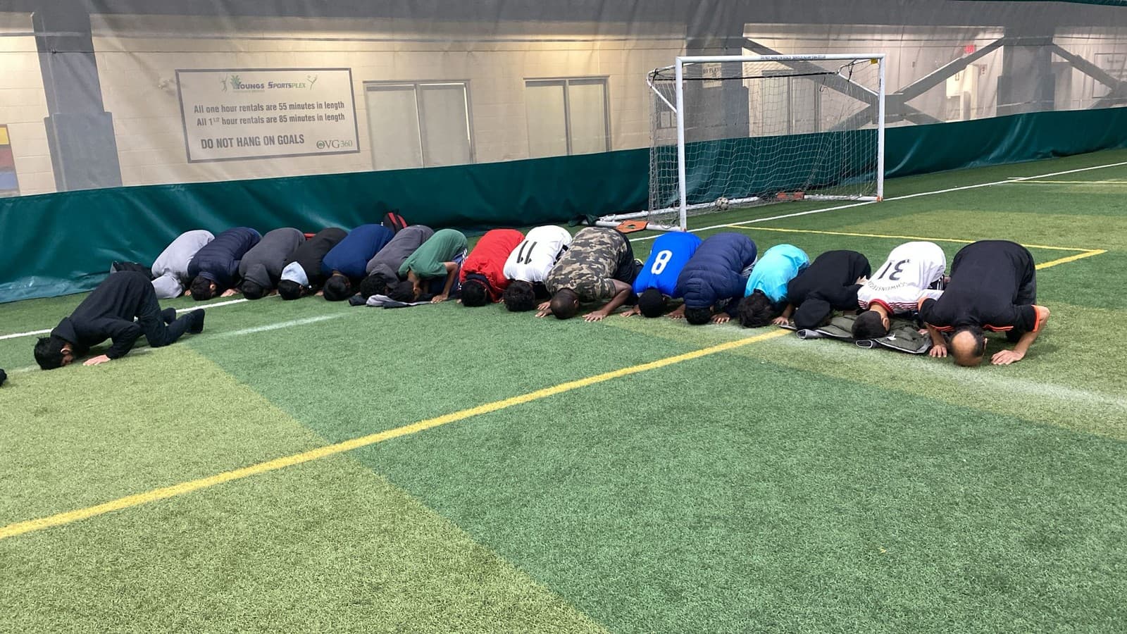 Players praying together on the soccer field