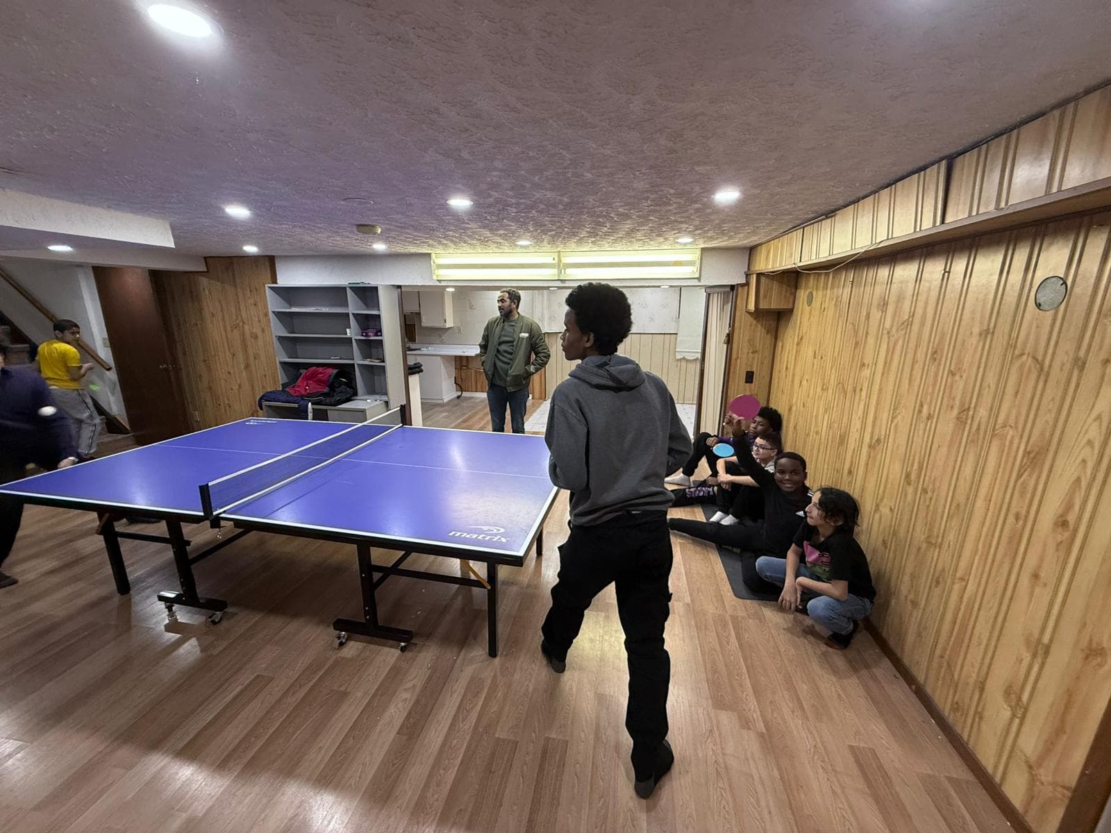 Kids playing ping pong in the community room